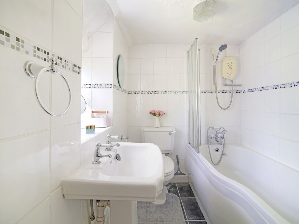 A bathroom with a sink, toilet, and bathtub at Lavender Cottage in Bourton, Dorset