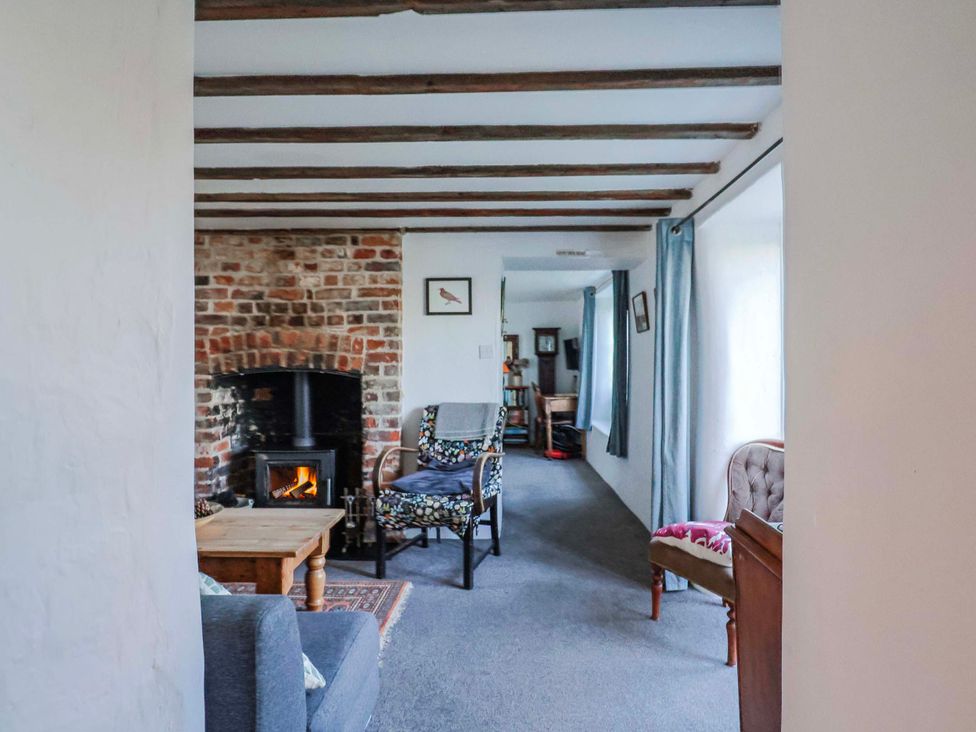 A living room with a fireplace and seating area at 2 Oak Tree Cottages Marshwood Nr. Hawkchurch
