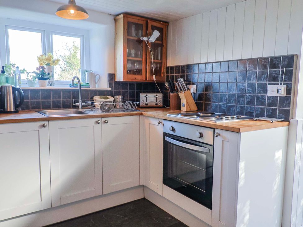 A kitchen with a sink and oven at 2 Oak Tree Cottages Marshwood Nr. Hawkchurch