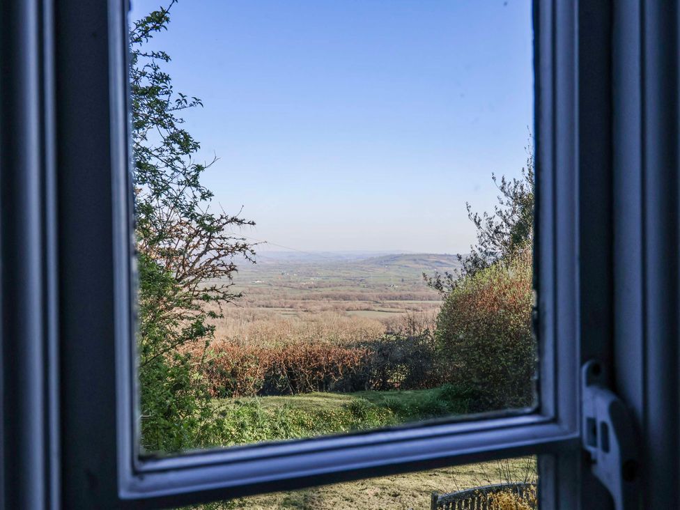 A view of hills and trees through a window at 2 Oak Tree Cottages Marshwood Nr. Hawkchurch