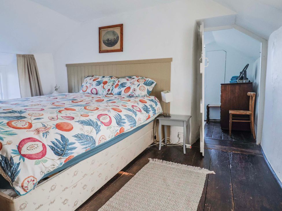A bedroom with a bed and a nightstand at 2 Oak Tree Cottages Marshwood Nr. Hawkchurch