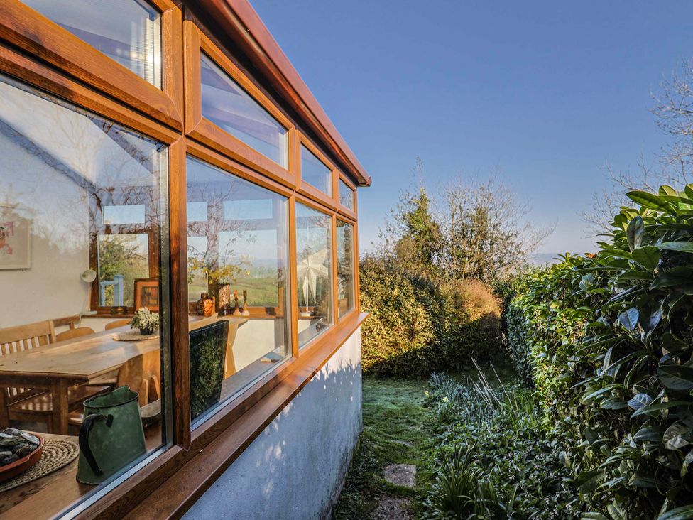 A conservatory with a dining table and chairs at 2 Oak Tree Cottages Marshwood Nr. Hawkchurch