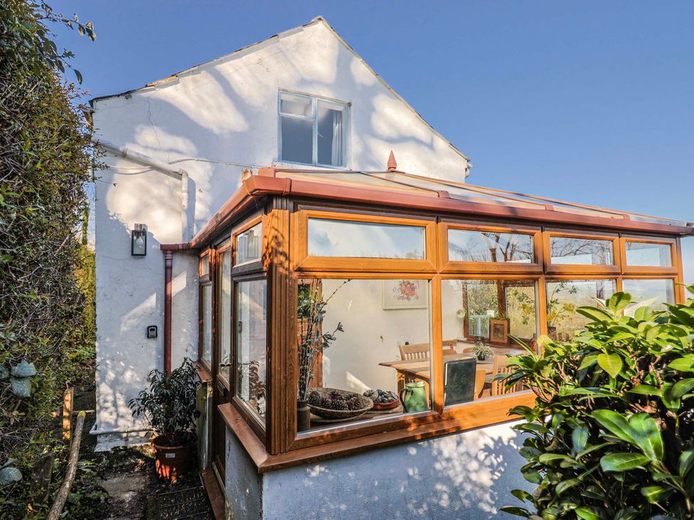 A conservatory with a table and chairs at 2 Oak Tree Cottages Marshwood Nr. Hawkchurch