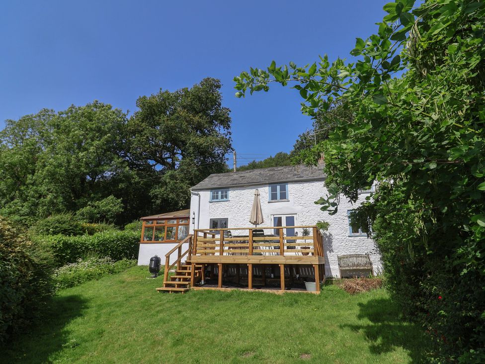 A house with a wooden deck and umbrella at 2 Oak Tree Cottages Marshwood Nr. Hawkchurch