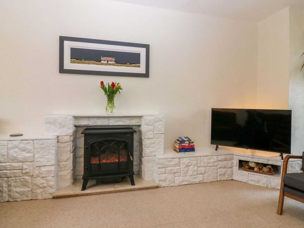 A living room with a fireplace and television at Parkhill in Dairsie