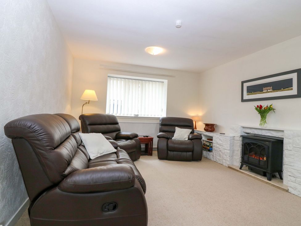 A living room with leather sofas and a fireplace at Parkhill in Dairsie