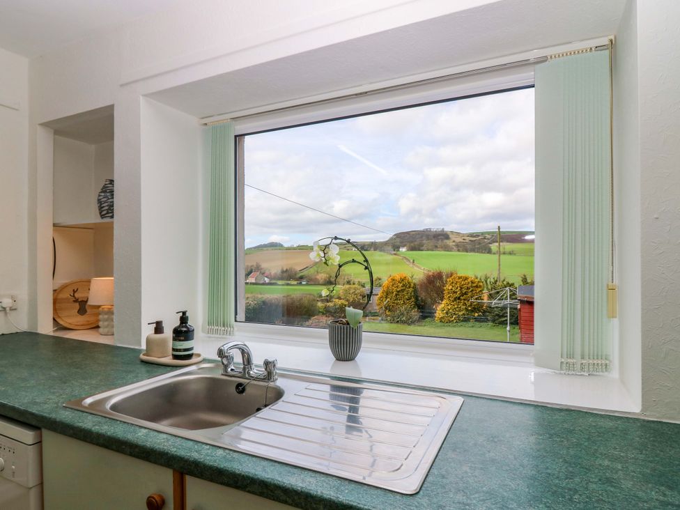 A kitchen with a sink and window overlooking fields at Parkhill in Dairsie