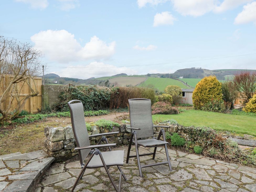 A garden with chairs and a stone patio at Parkhill in Dairsie