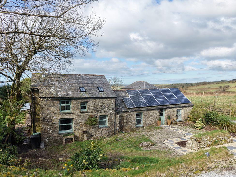 An outdoor view of a stone house with solar panels at Tor Farm Advent near Camelford