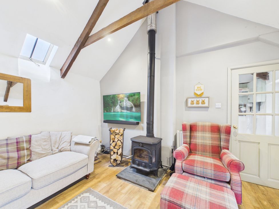 A living room with a wood stove and television at Tor Farm Advent near Camelford