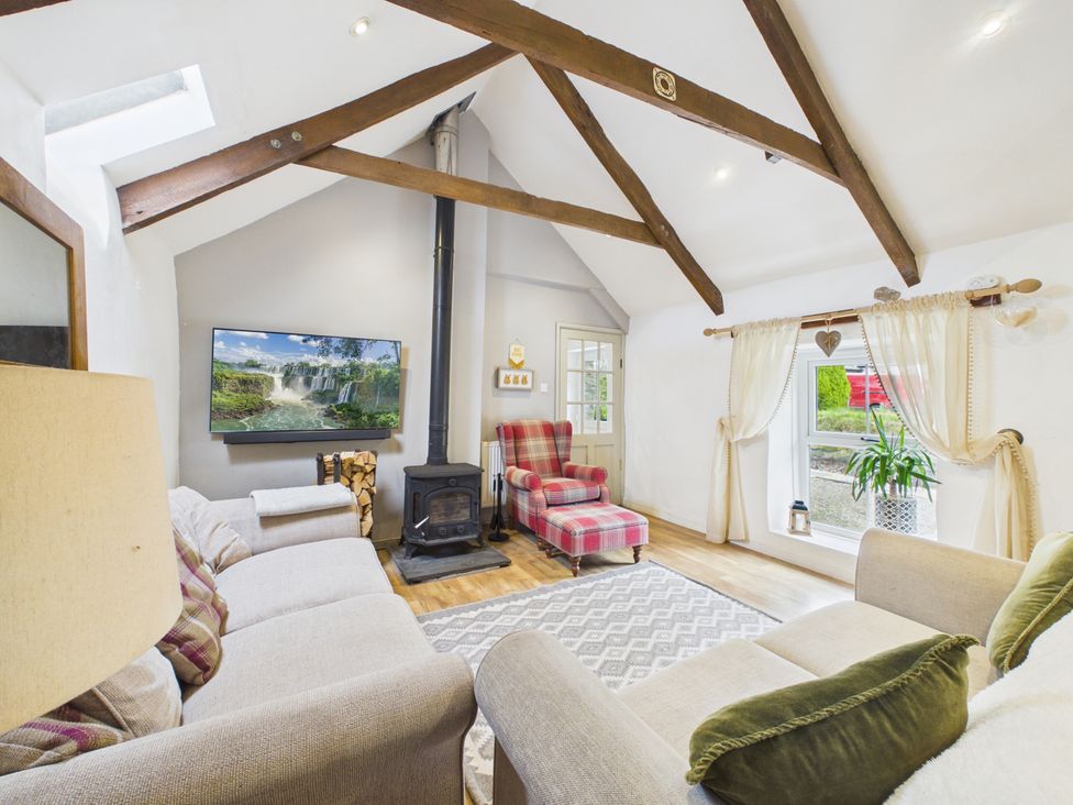 A living room with a television and a fireplace at Tor Farm in Advent near Camelford