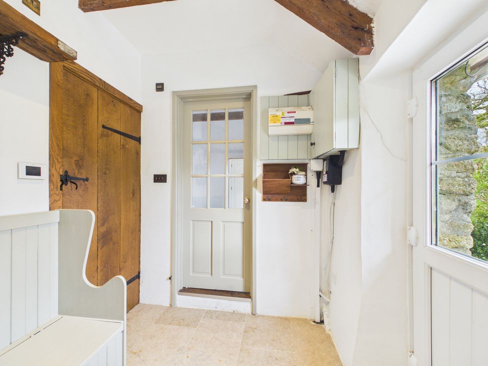 A hallway with a door and bench at Tor Farm Advent near Camelford
