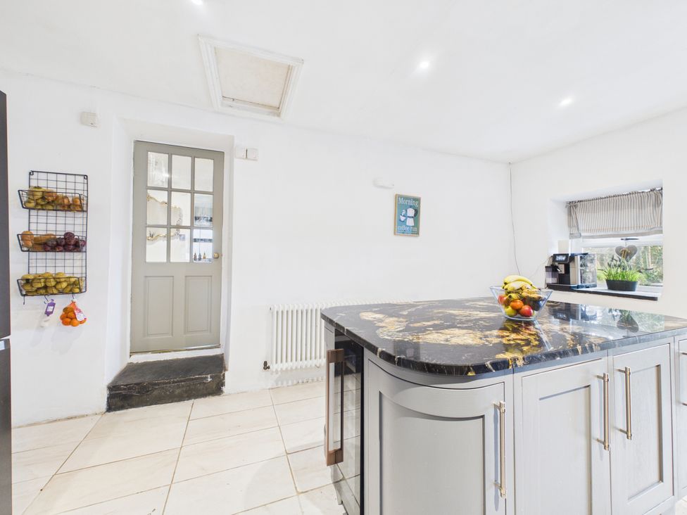 A kitchen with a door and fruit bowl at Tor Farm in Advent near Camelford