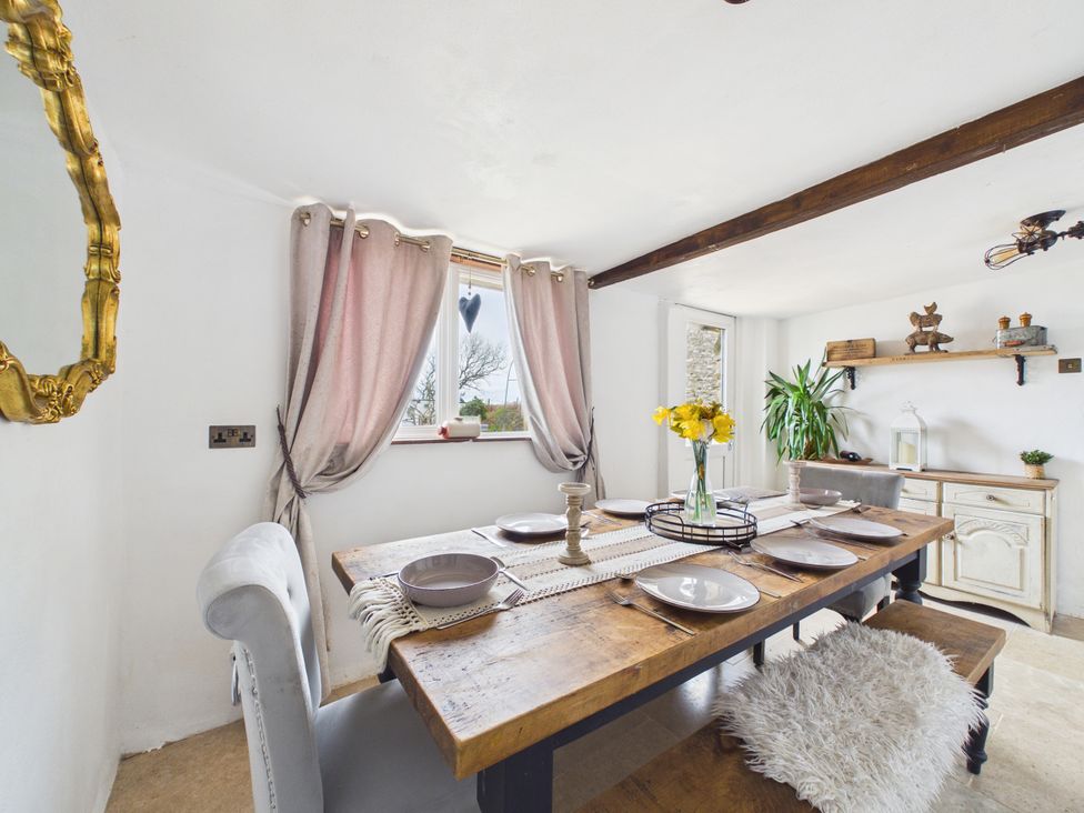 A dining room with a wooden table and chairs at Tor Farm Advent near Camelford