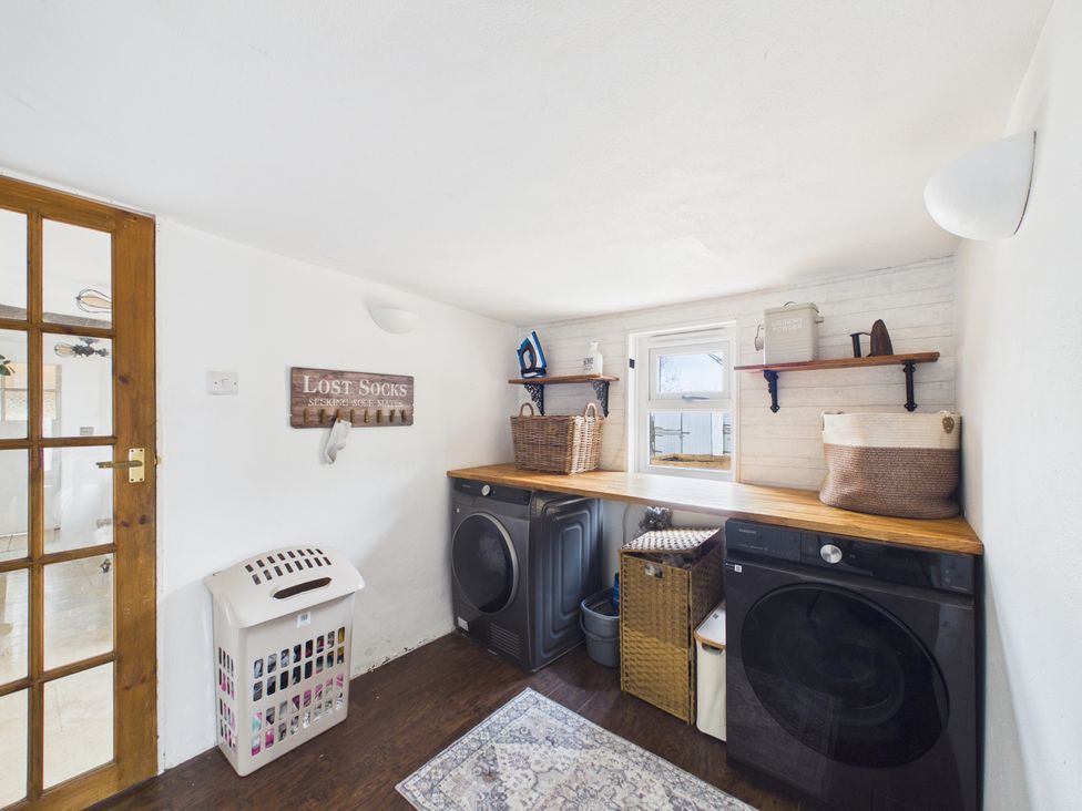 A laundry room with washing and drying machines at Tor Farm in Advent near Camelford