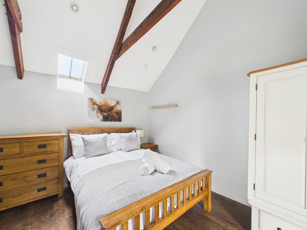 A bedroom with a bed and wooden furniture at Tor Farm in Advent near Camelford