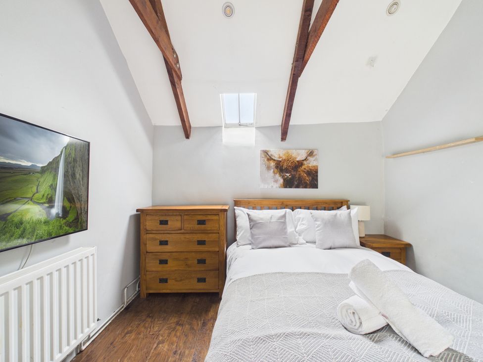 A bedroom with a bed, chest of drawers, and a TV at Tor Farm Advent near Camelford