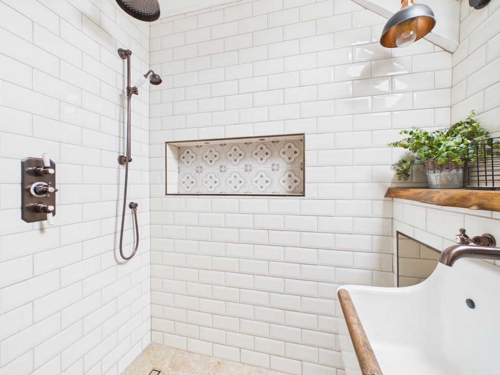 A bathroom featuring a shower area and bathtub at Tor Farm Advent near Camelford