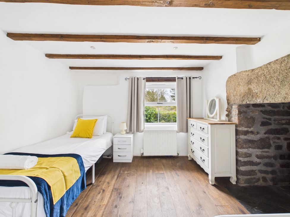 A bedroom with a bed and dresser at Tor Farm in Advent near Camelford