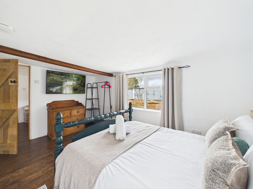 A bedroom with a bed and a television at Tor Farm Advent near Camelford