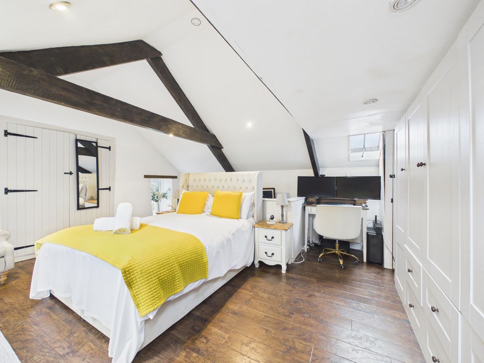 A bedroom with a bed, desk, and wardrobe at Tor Farm in Advent near Camelford