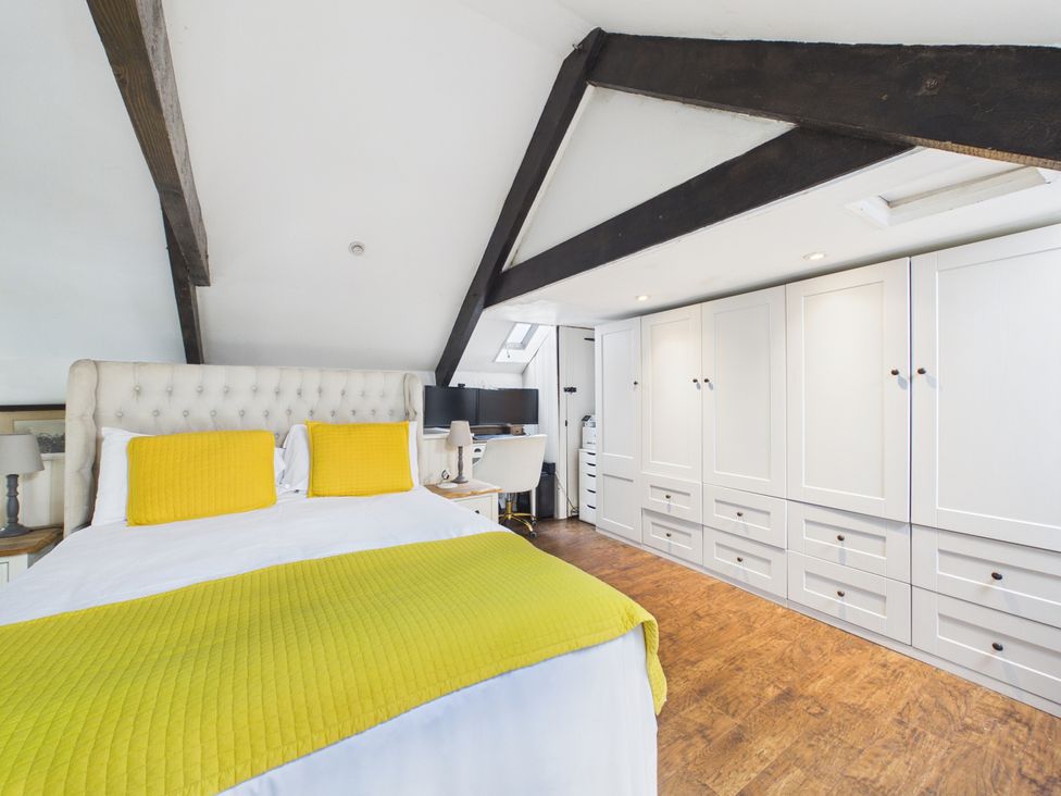 A bedroom with a bed, desk, and storage at Tor Farm in Advent near Camelford