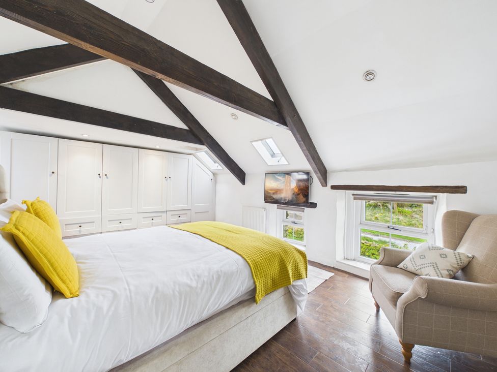 A bedroom with a bed and wardrobe at Tor Farm in Advent near Camelford