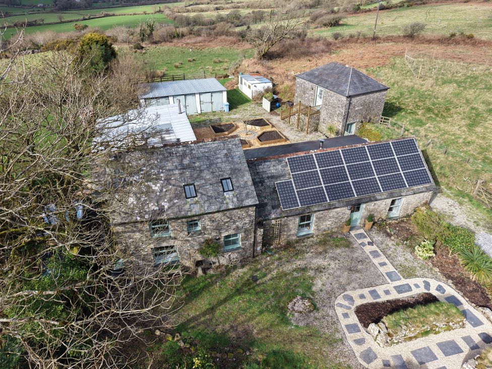 An outdoor view of a building with solar panels and a garden at Tor Farm Advent near Camelford