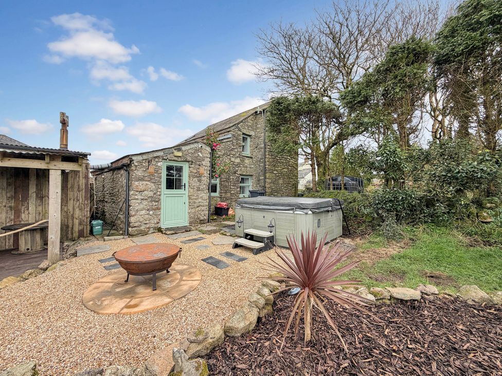 A garden with a hot tub and outdoor seating at Tor Farm Advent near Camelford