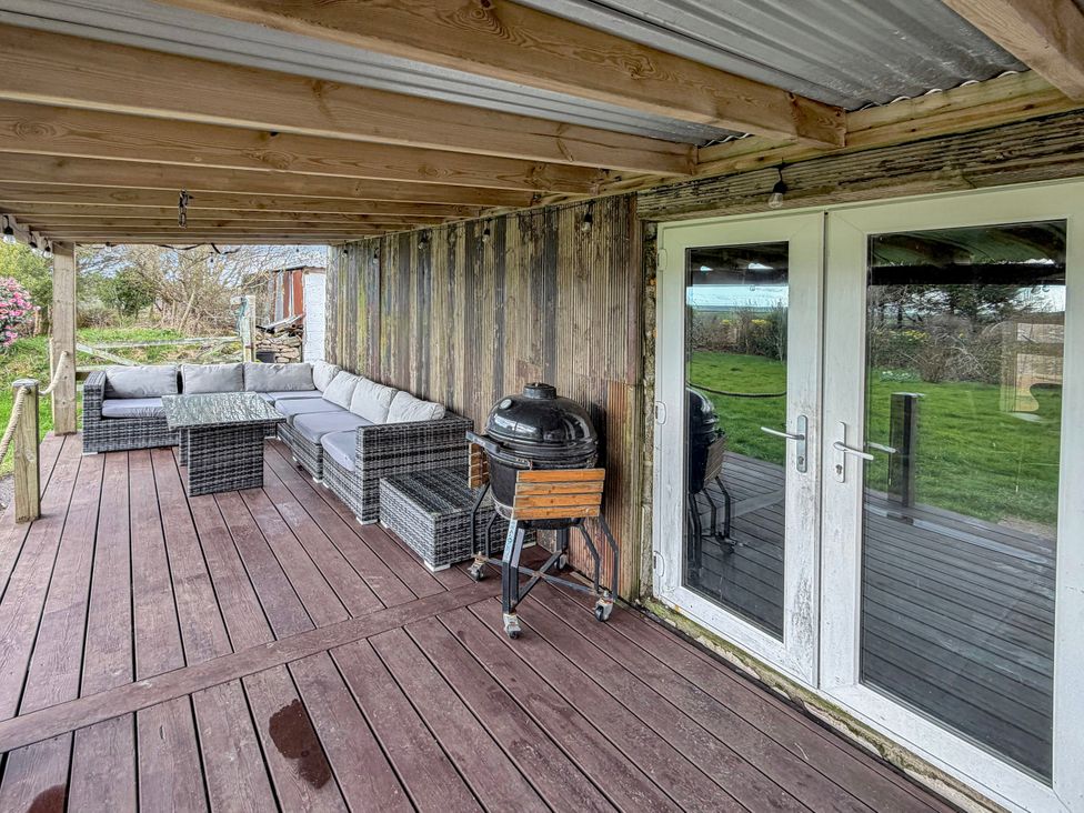 An outdoor seating area with a sofa and barbecue grill at Tor Farm Advent near Camelford