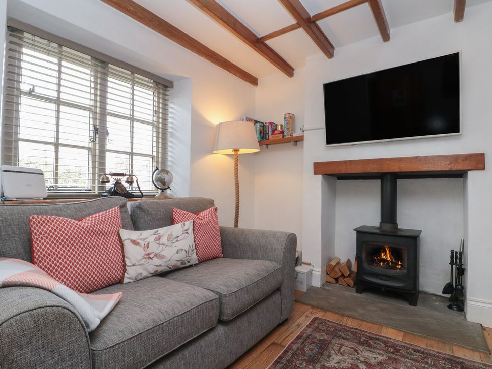 A living room with a sofa and a television at Isla cottage
