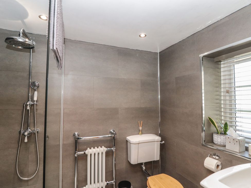 A bathroom with a shower, toilet, and sink at Isla cottage