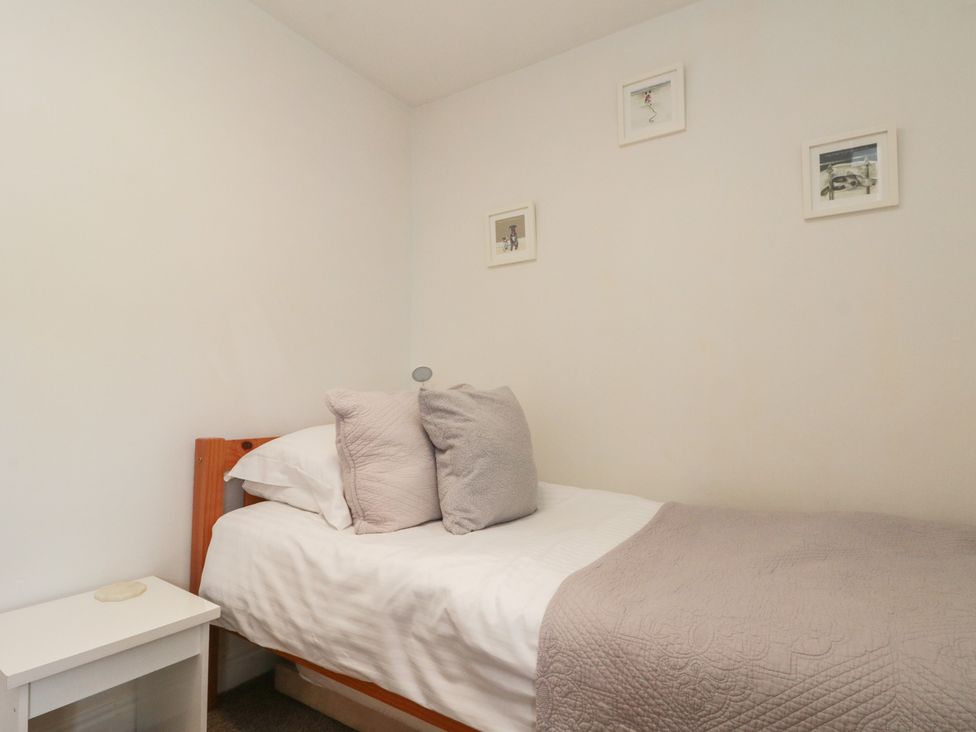 A bedroom with a bed and decorative frames at Isla cottage