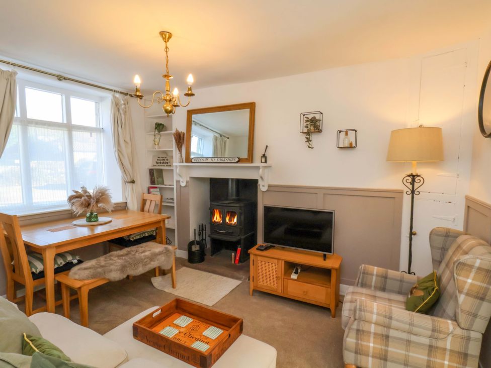 A living room with a dining table, sofa, and fireplace at 1 Rosedale Abbey