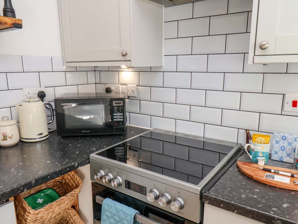 A kitchen with a stovetop and microwave at 1 Rosedale Abbey