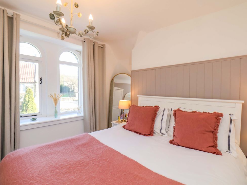 A bedroom with a bed and decorative items at 1 Rosedale Abbey