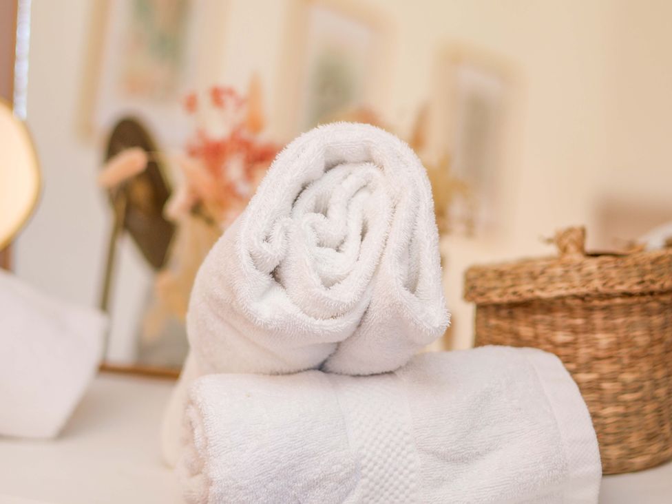A rolled pair of towels with a basket in a bathroom at 1 Rosedale Abbey