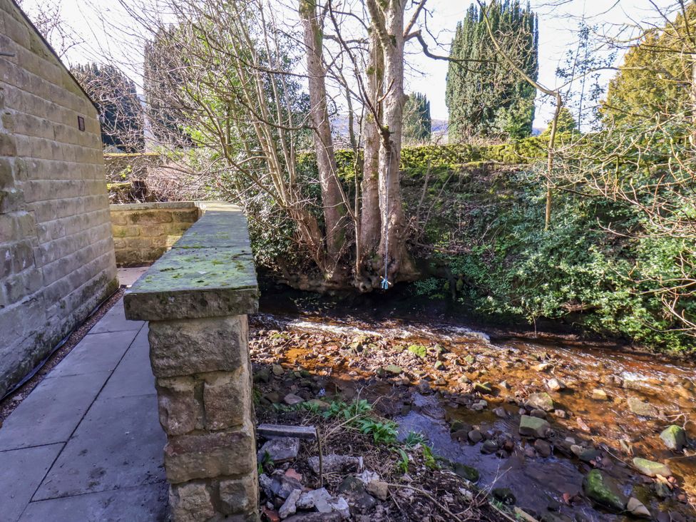 A path beside a stream with trees and a stone wall at 1 Rosedale Abbey
