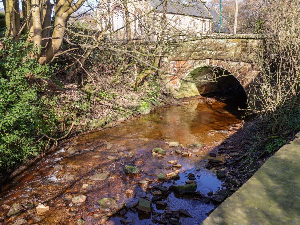 A bridge over a stream with rocks and trees at 1 Rosedale Abbey