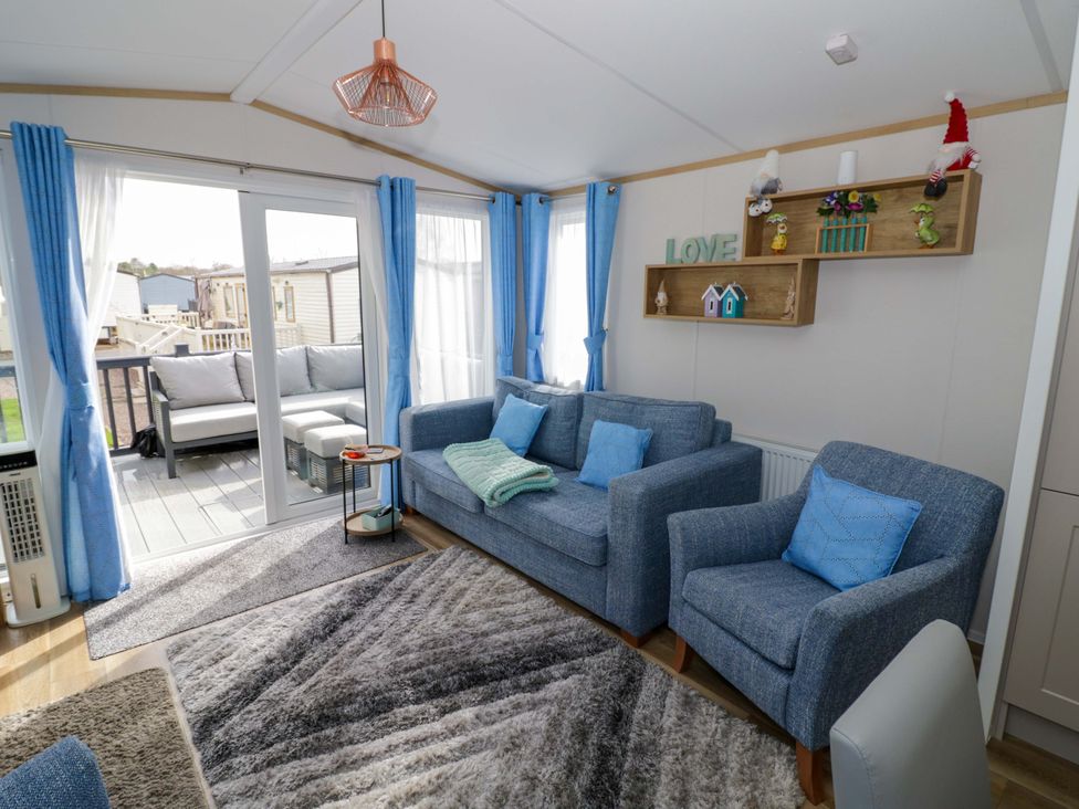 A living room with a sofa and table at AV18 in Tiddington