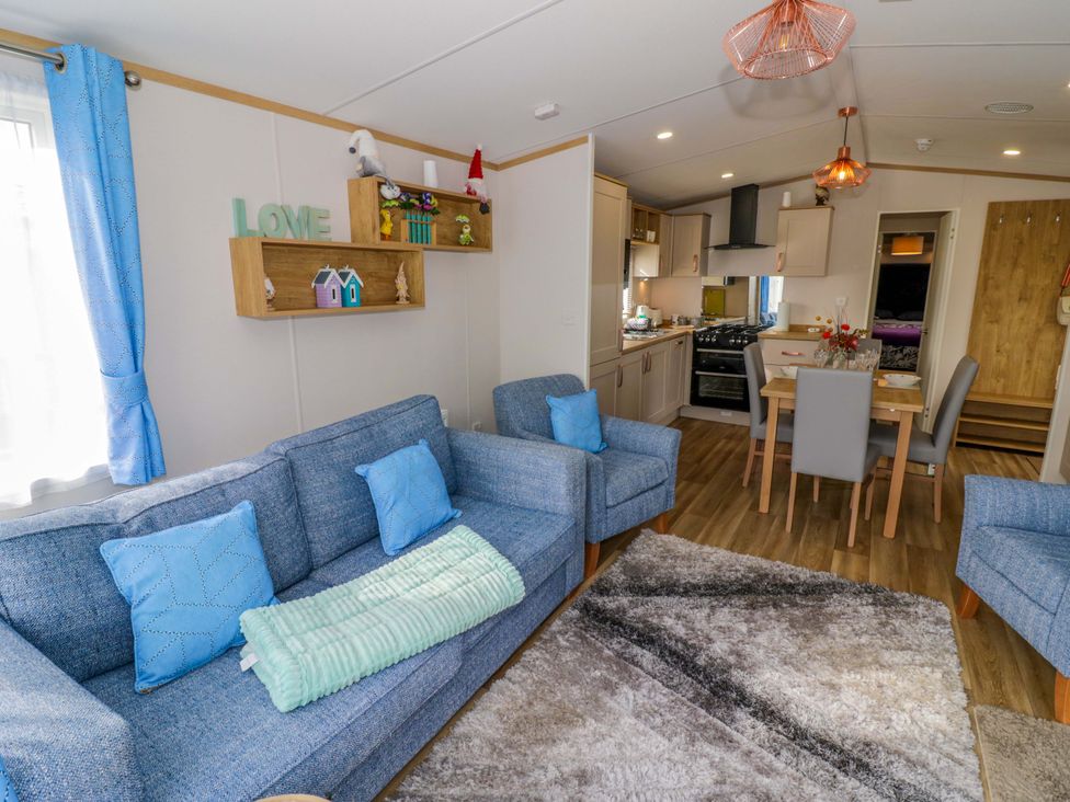 A living room with a sofa and a dining area at AV18 in Tiddington