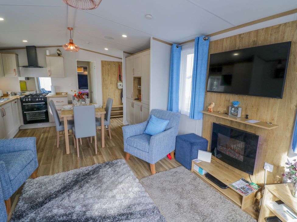 A living room with a kitchen area and dining table at AV18 Tiddington