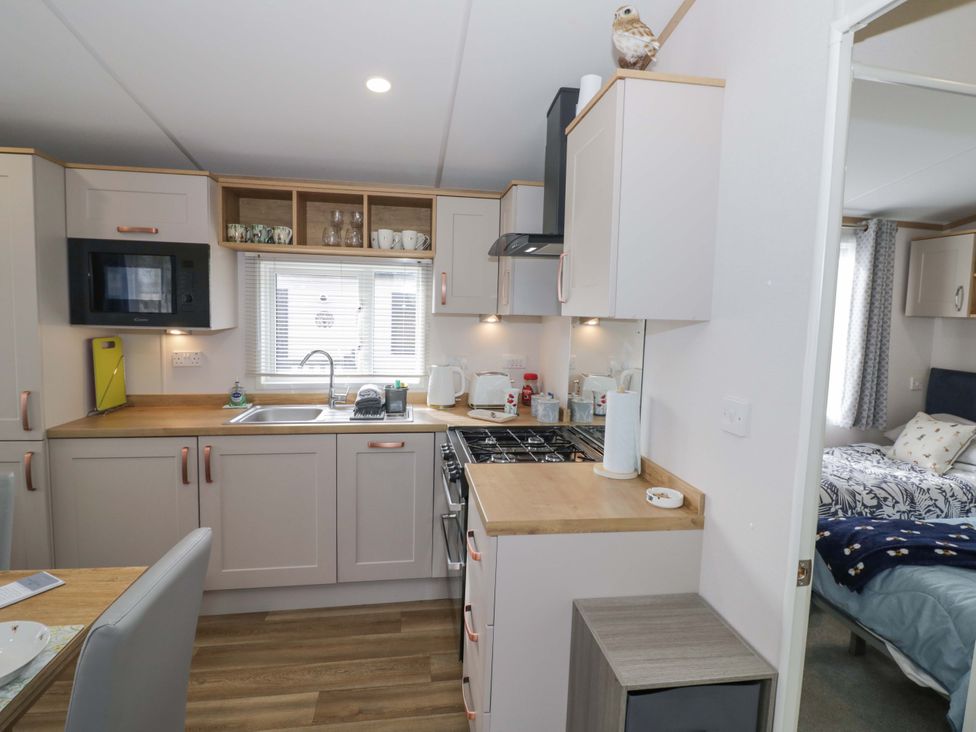 A kitchen with appliances and a dining table at AV18 in Tiddington