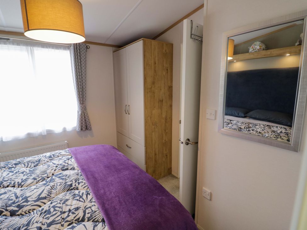 A bedroom with a bed and wardrobe at AV18 in Tiddington
