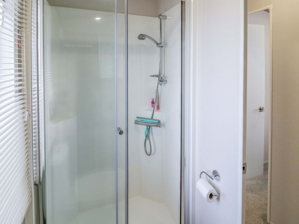 A shower with a glass door and towel holder at AV18 in Tiddington
