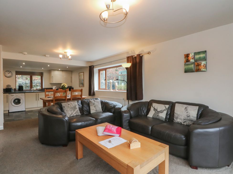 A living room with sofas, a coffee table, and a washing machine at Victoria Wood View in Cragg Vale