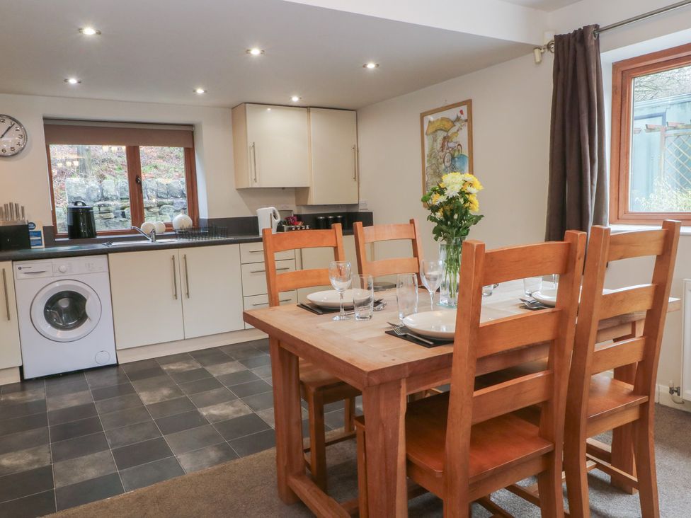 A kitchen with a dining table and washing machine at Victoria Wood View, Cragg Vale