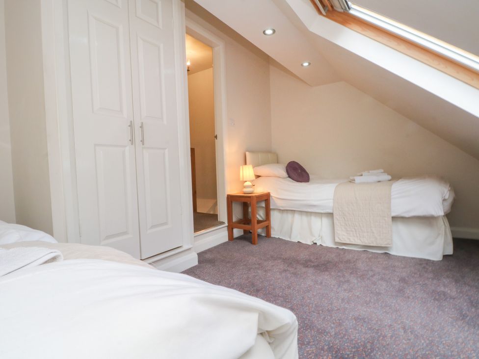A bedroom with two beds and a wardrobe at Victoria Wood View in Cragg Vale