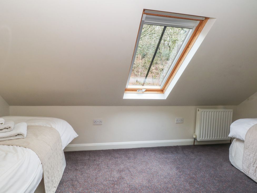 A bedroom with two beds and a window at Victoria Wood View in Cragg Vale