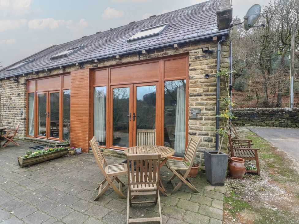 An outdoor seating area with a dining table and chairs at Victoria Wood View Cragg Vale